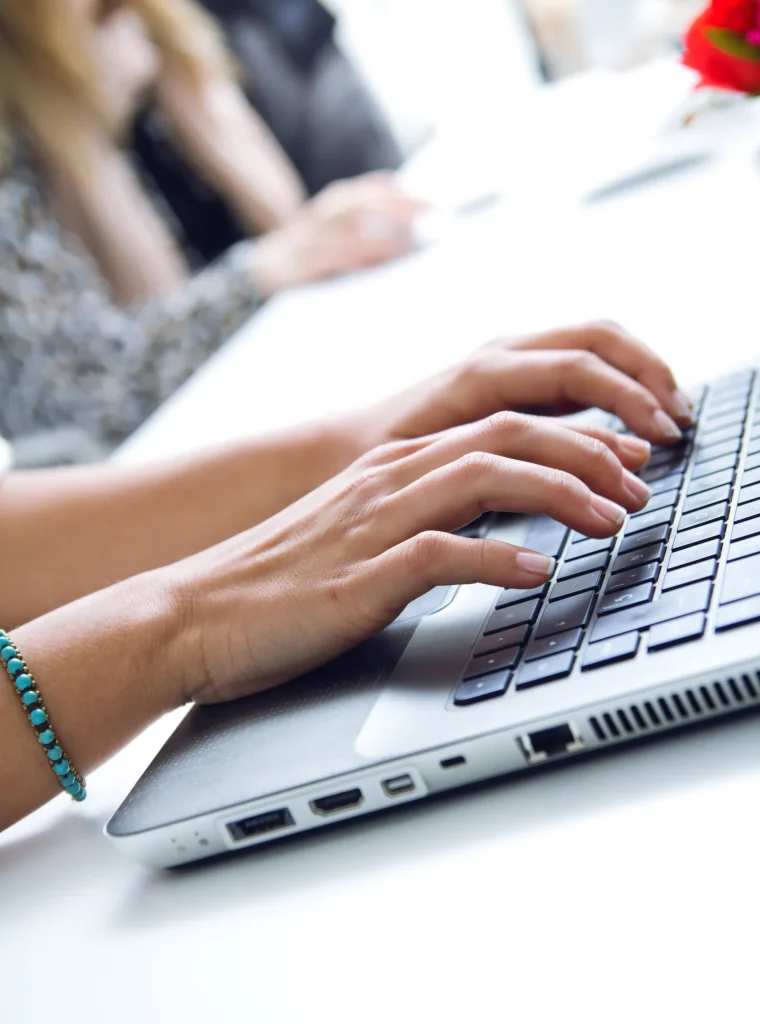 manos-de-mujer-escribiendo-en-la-computadora-portatil