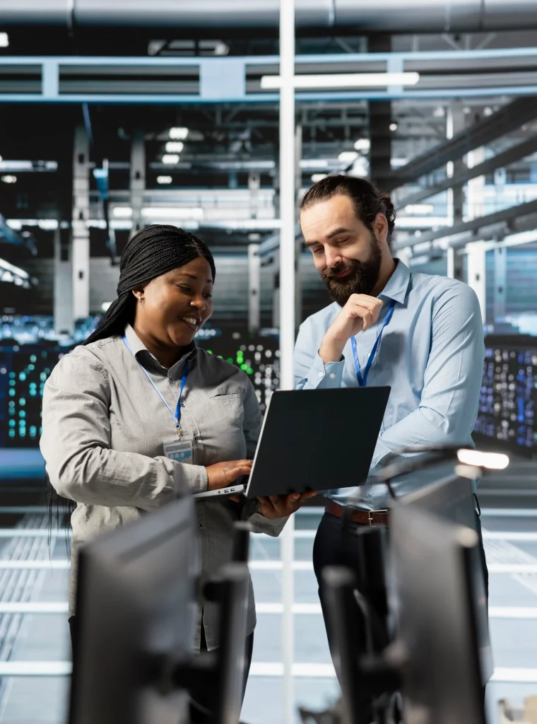 un-equipo-alegre-de-ingenieros-usando-una-computadora-portatil-en-una-granja-de-servidores-analizando-datos
